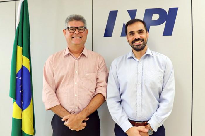 El director Santiago Martínez lideró la visita a Brasil Director Santiago Martínez, junto a otro hombre, sonríen junto a una bandera de Brasil