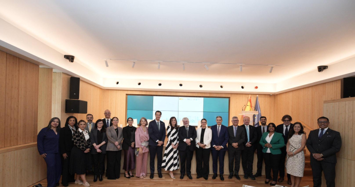 Participantes de la conferencia de alto nivel de IBEPI, en España. 21 personas paradas con una pantalla detrás
