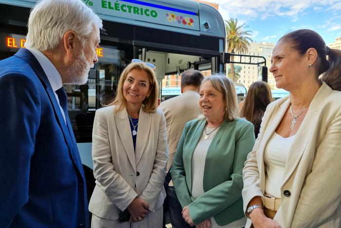 Presentación de ómnibus eléctricos de Cutcsa La ministra Facio dialoga con otras personas, con un ómnibus de fondo