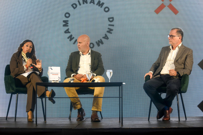 Cardona habla, sentada, junto a Legnani y Gili; detrás, pantalla con el nombre del evento