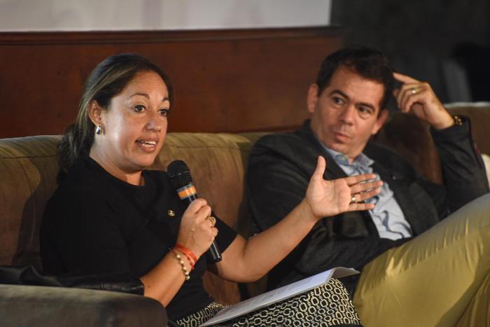 La ministra Fernanda Cardona y el presidente de la CIU, Leonardo García, cerraron el evento Ministra Cardona habla con un micrófono, sentada junto al presidente de la CIU