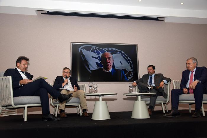 Panel en el que participó el ministro Paganini: cuatro hombres sentados en sillones