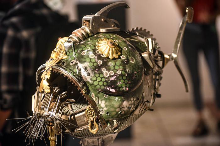 Artesanía premiada Artesanía en color verde y dorado: parece un pez prehistórico y tiene algo de máquina