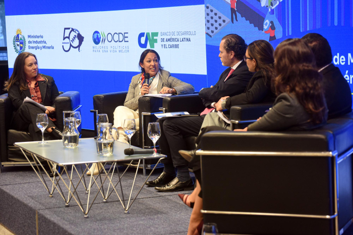Panel de apertura: oradores sentados en sillones; Cardona habla; detrás, pantalla