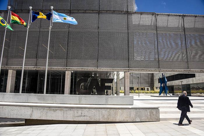 Fachada de CAF-Banco de Desarrollo de América Latina Fachada de CAF-Banco de Desarrollo de América Latina; se ven banderas de varios países y una persona
