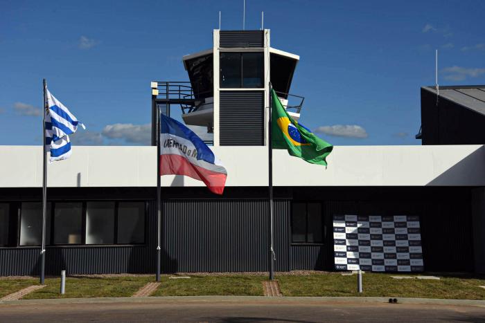 Fachada del aeropuerto; se ven la bandera uruguaya, la brasilera y la de los Treinta y Tres 