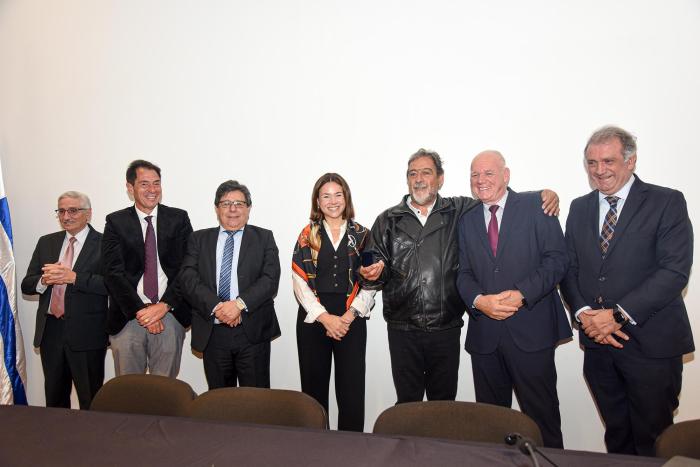 Autoridades del MIEM participaron de ceremonia que reconoció a los funcionarios del Correo Uruguayo Funcionario recibe medalla junto a autoridades, de pie