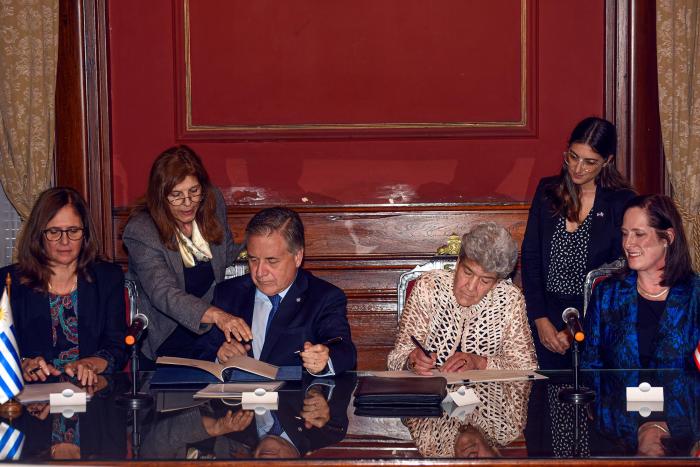 Autoridades firman el memorando: en la mesa, Facio, Paganini, Lago y Fulton; detrás, funcionarias