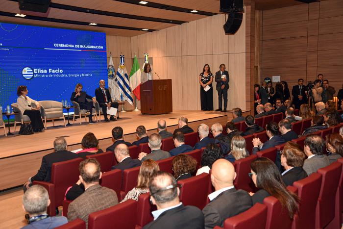 Auditorio visto de atrás; al fondo, la ministra habla desde un atril; a su lado, autoridades