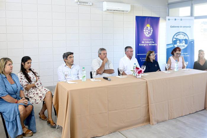 Autoridades y funcionarios de las instituciones participaron del lanzamiento del programa Grupo de autoridades y representantes de organismos, sentados en una mesa; detrás hay banners