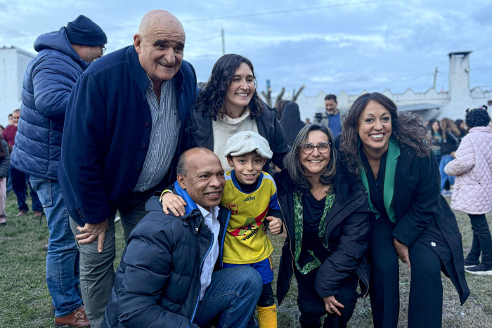 Autoridades y niños con boina sonríen de pie y en cuclillas