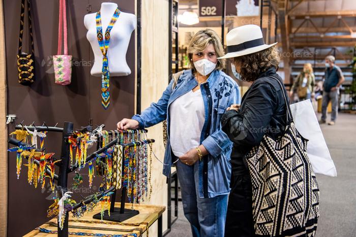 Dos mujeres observan artesanías en un stand