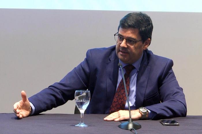 Director nacional de Energía, Fitzgerald Cantero Habla frente a un micrófono el director Fitzgerald Cantero; está en una mesa que tiene una copa