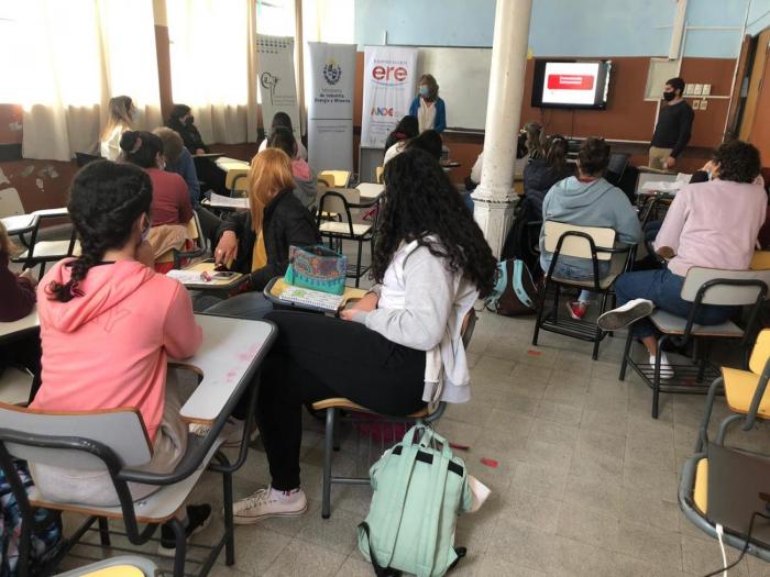 Taller 1: en un salón de clases se ven estudiantes de espaldas y un docente en el fondo