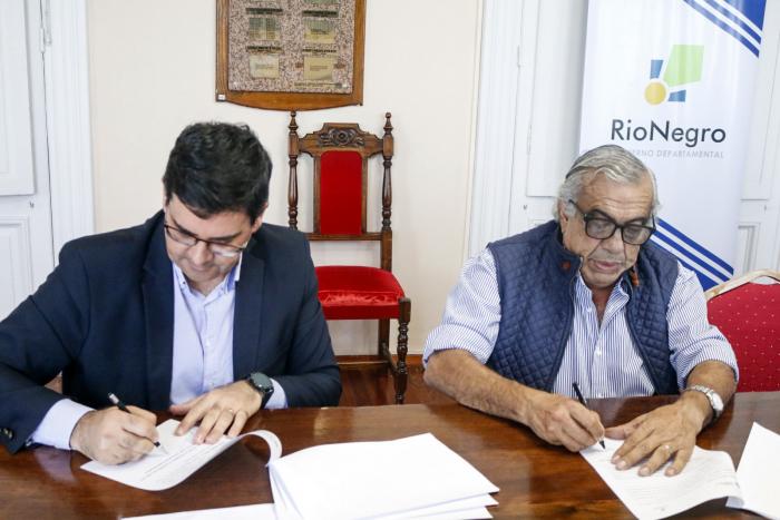 Cantero firma el convenio junto a Lafluf; están sentados en una mesa