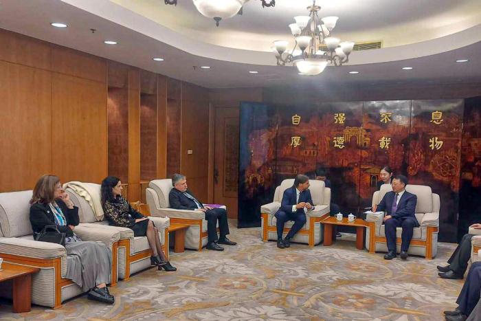 Reunión en la universidad de Tsinghua Las autoridades y los representantes chinos están sentados en sillones en una gran oficina
