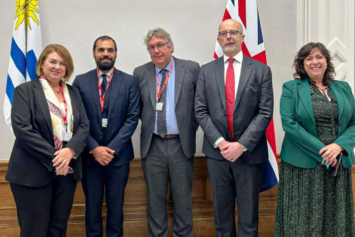 Autoridades uruguayas y británicas Autoridades uruguayas y británicas, de pie; detrás, banderas de ambos países