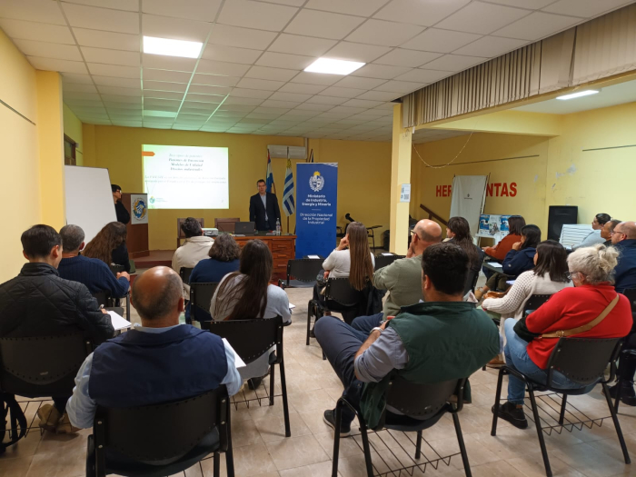 Personas sentadas miran a un profesor
