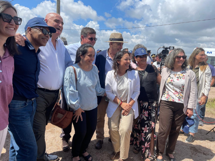 Ministra Cardona sonríe junto a un grupo de personas, de pie