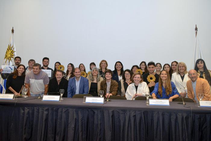 Ganadores del Premio Uruguay Circular 2024, junto a técnicos y autoridades Ganadores del premio, con premios y diplomas, detrás de una mesa
