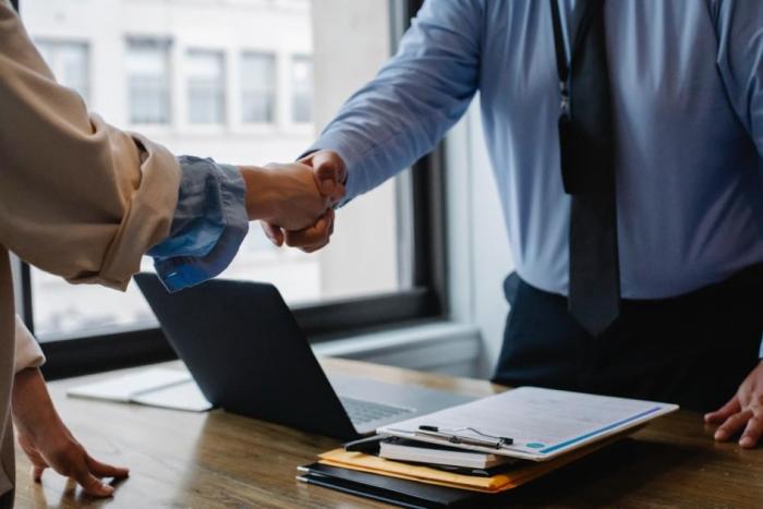 El nuevo programa permite profundizar la colaboración entre las oficinas de Prosur Dos personas se dan la mano. Entre ellos hay una mesa y una laptop