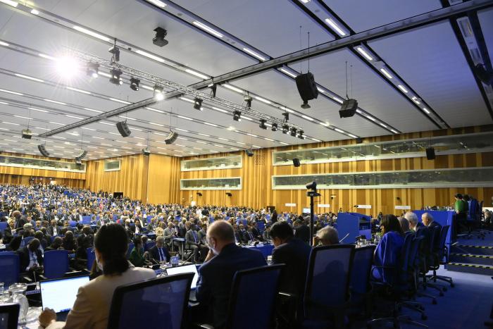 Un grupo numeroso de personas está reunido en un amplio salón