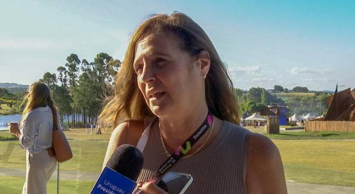 Ministra Facio, frente a un micrófono; al fondo, campo en un día soleado