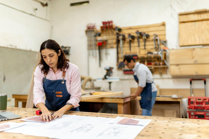 Mujer y hombre, con delantales, trabajan en un taller