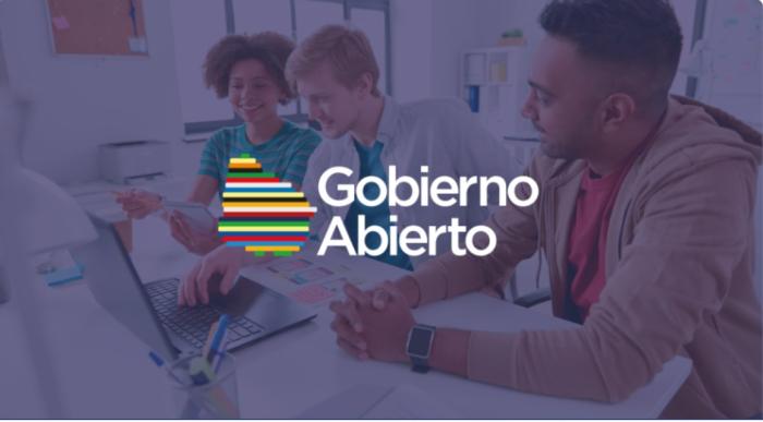 imagen de Uruguay en colores, texto que dice Gobierno Abierto y de fondo personas frente a laptop