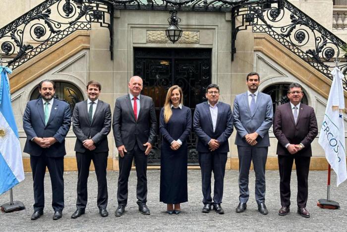 Grupo de jerarcas participantes de la reunión Grupo de hombres, y una mujer, posan frente a un edificio antiguo; entre ellos está Verri