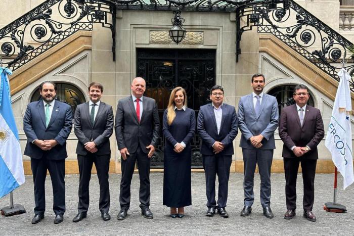 Grupo de hombres, y una mujer, posan frente a un edificio antiguo; entre ellos está Verri