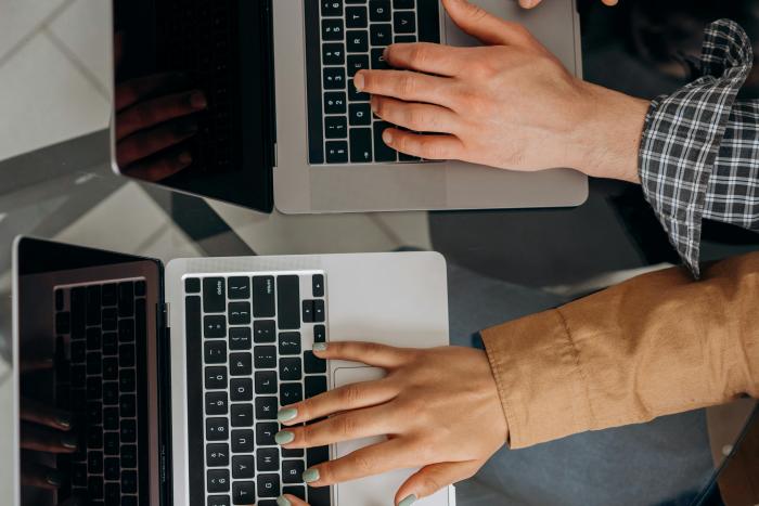 Dos pasantes colaborarán con el desarrollo de las mipymes de Río Negro, gracias al apoyo del MIEM Manos de un joven y de una joven que escriben en laptops