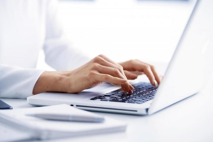 Interrupción de servicios de trámites en línea del MIEM-DNE Detalle de manos arriba de un teclado de laptop