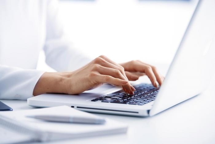 Manos escriben en una laptop