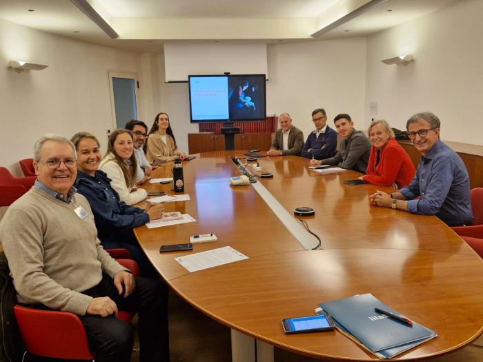 Grupo de personas, reunidas alrededor de una mesa de madera
