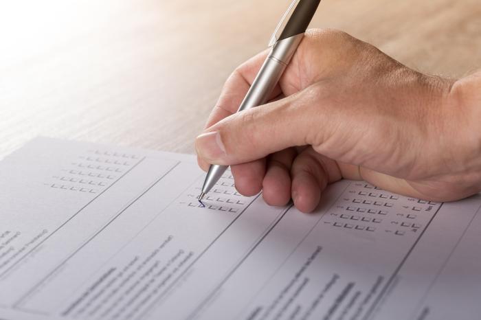 Se muestra una mano completando un formulario