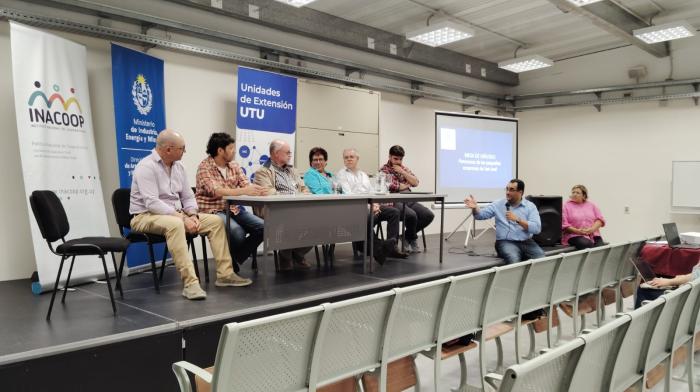 Panel de expositores sentados en una mesa
