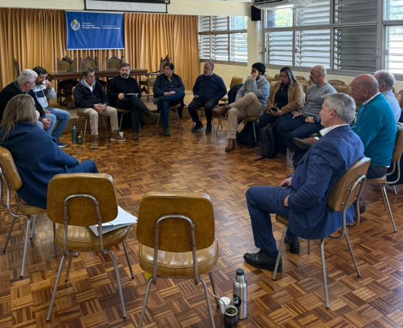 Participantes de la reunión, sentados y sentadas en círculo