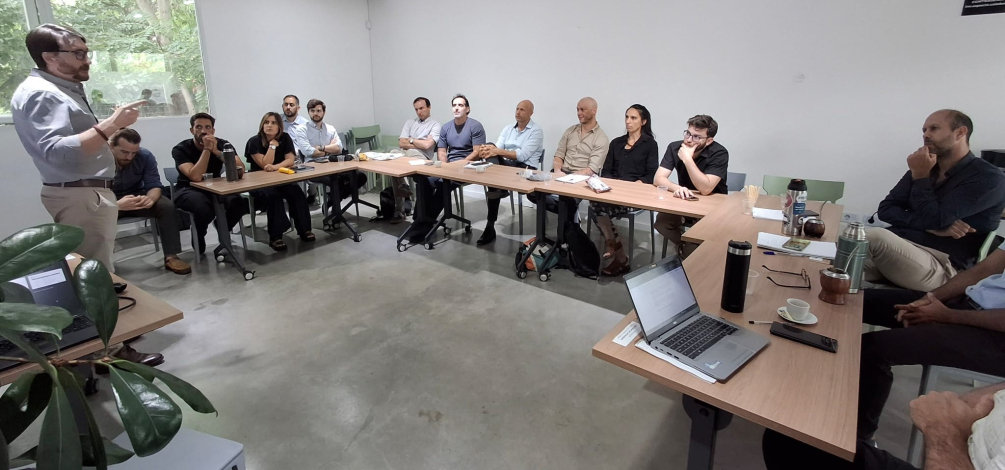 Pesona de pie, ante personas sentadas en mesas en forma de círculo