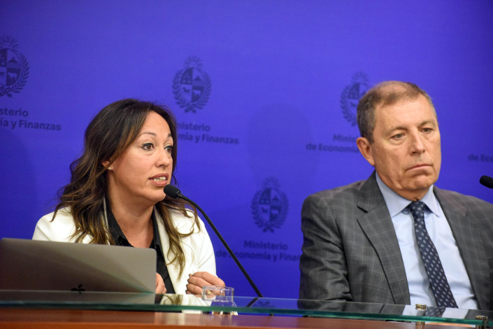 Ministra Cardona y ministro Oddone sentados. Al fondo back azul