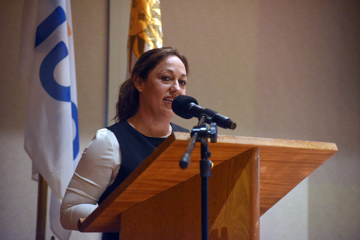 Cardona habla desde un atril; detrás, banderas de Uruguay y de UTE