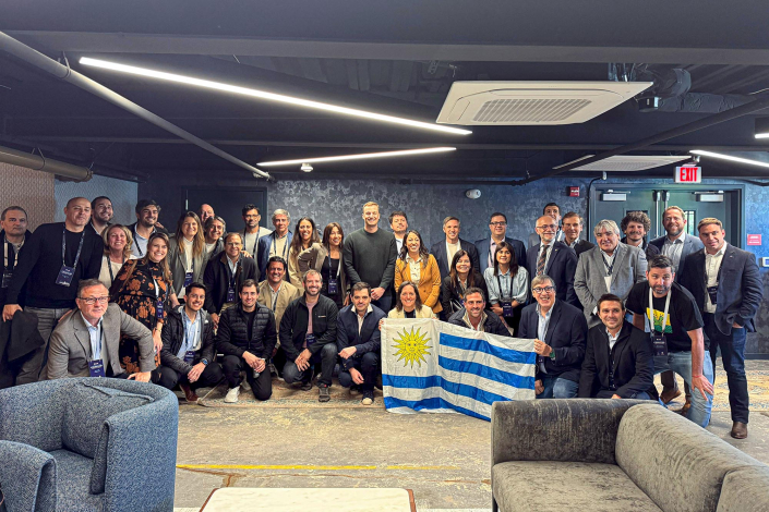 Personas de pie y en cuclillas, con bandera de Uruguay