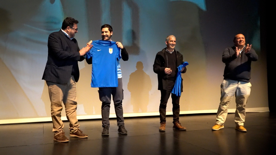 Entrega de camisetas Cuatro personas sobre el escenario
