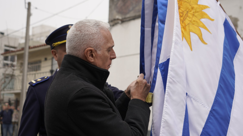 Ministro, colocando la medalla al mérito policial en grado de plata al pabellón nacional