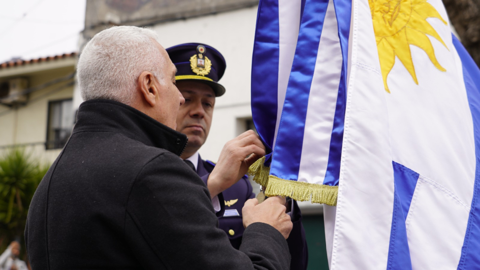 Ministro, colocando la medalla al mérito policial en grado de plata al pabellón nacional