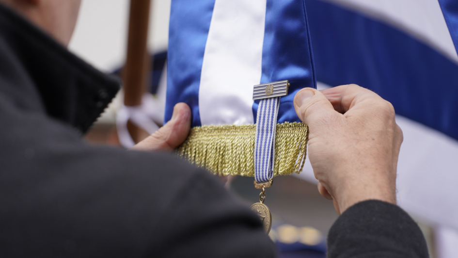 Ministro, colocando la medalla al mérito policial en grado de plata al pabellón nacional