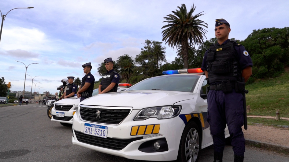 Policías parados al lado del un patrullero 