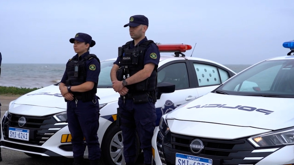 Policías parados al lado del un patrullero 