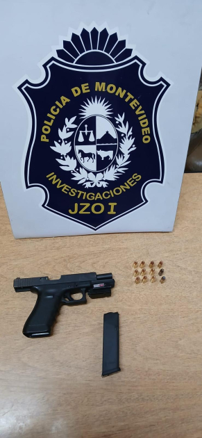 Arma incautada en allanamiento Arma del instituto policial incautada tras hurto exhibida sobre la mesa