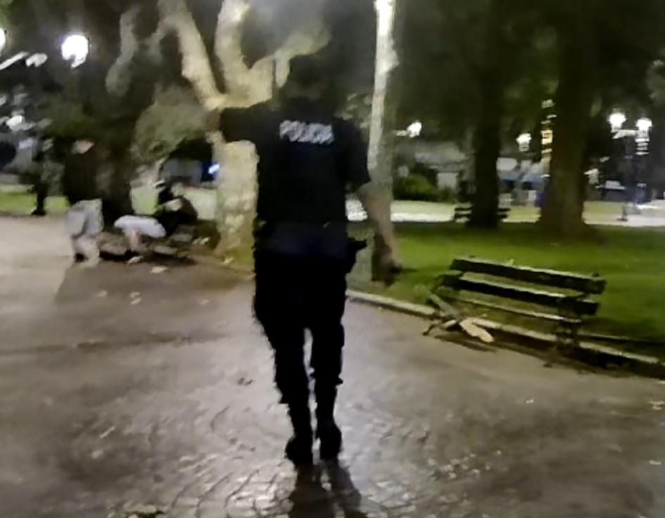 Policía de espalda indentificando a adolescentes que dañaron banco de plaza Libertad Policía de espalda indentificando a adolescentes que dañaron banco de plaza Libertad